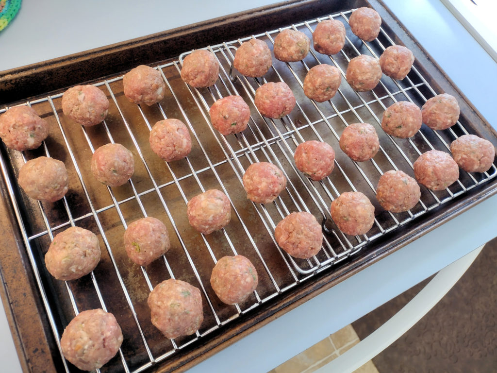 Ikea Meatballs Hovering Above The Cookie Sheet Before Baking